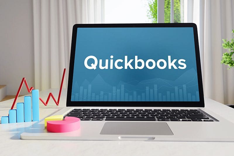 Laptop showing the QuickBooks name beside charts